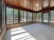 Bright sunroom with brick accents, large windows offering outdoor views, and a concrete floor at 12610 Bay Hill Dr, Grand Island, FL 32735