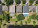 Aerial view of houses with screened pools and well-maintained lawns backing to a lake at 12822 Moss Park Ridge Dr, Orlando, FL 32832