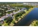 Scenic aerial view of homes near a lake, featuring lush landscaping and a fountain at 12822 Moss Park Ridge Dr, Orlando, FL 32832