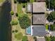 Aerial view features backyards with screened-in pools and scenic waterfront views, set amidst a verdant landscape at 12822 Moss Park Ridge Dr, Orlando, FL 32832
