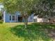 Backyard view showcases the home's exterior and highlights the spacious lawn surrounded by mature trees at 12822 Moss Park Ridge Dr, Orlando, FL 32832