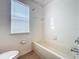 Bathroom featuring a shower-tub combination and a bright window at 12822 Moss Park Ridge Dr, Orlando, FL 32832