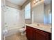 Bathroom featuring a shower-tub combo, white tiles, and a cherry wood vanity at 12822 Moss Park Ridge Dr, Orlando, FL 32832