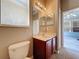 Bright bathroom showcasing a cherry wood vanity and view of the exterior patio at 12822 Moss Park Ridge Dr, Orlando, FL 32832