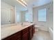 Clean bathroom featuring a cherry wood vanity, large mirror, and shower-tub combination at 12822 Moss Park Ridge Dr, Orlando, FL 32832
