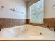 Corner bathtub with tile surround, creating a relaxing spa-like experience at 12822 Moss Park Ridge Dr, Orlando, FL 32832