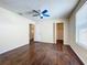 Bedroom features wood floors, ceiling fan, and view into walk-in closet at 12822 Moss Park Ridge Dr, Orlando, FL 32832