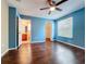 Bright bedroom with hardwood floors, ceiling fan, and ensuite bathroom and closet at 12822 Moss Park Ridge Dr, Orlando, FL 32832