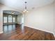 Well-lit dining room with hardwood floors, a chandelier, and views into living room at 12822 Moss Park Ridge Dr, Orlando, FL 32832