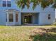 Exterior view of the home features a backyard with sliding glass doors and a bay window at 12822 Moss Park Ridge Dr, Orlando, FL 32832