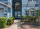 Beautiful entryway with double doors, transom window, and manicured landscaping at 12822 Moss Park Ridge Dr, Orlando, FL 32832