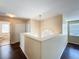 Upstairs hallway with wood floors, white railing, and natural light at 12822 Moss Park Ridge Dr, Orlando, FL 32832