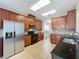 Bright kitchen with cherry cabinets, tile flooring, and stainless steel refrigerator at 12822 Moss Park Ridge Dr, Orlando, FL 32832