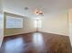 Bright living room showcasing hardwood floors, three windows, and a ceiling fan for added comfort at 12822 Moss Park Ridge Dr, Orlando, FL 32832