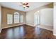 Bright and airy living room featuring hardwood floors, fan, and decorative front doors at 12822 Moss Park Ridge Dr, Orlando, FL 32832