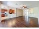 Spacious living room featuring hardwood floors, ceiling fan, and seamless flow to the kitchen at 12822 Moss Park Ridge Dr, Orlando, FL 32832