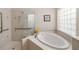 Elegant bathroom with tub, walk-in shower, and decorative tile accents at 1320 Antrim Cir, Ormond Beach, FL 32174
