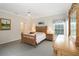 Comfortable bedroom with natural lighting, wood furniture, carpet floors, and access to the bathroom at 1320 Antrim Cir, Ormond Beach, FL 32174