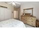 This bright bedroom features a ceiling fan, closet, and wood dresser with a mirror at 1320 Antrim Cir, Ormond Beach, FL 32174