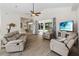 Spacious living room with hardwood floors, comfortable leather seating, a ceiling fan, and a view into the sunroom at 1320 Antrim Cir, Ormond Beach, FL 32174