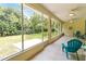 Relaxing sunroom with screened windows, tiled floor, ceiling fans, and tranquil views of the green landscaped backyard at 1320 Antrim Cir, Ormond Beach, FL 32174