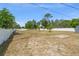 Large backyard bordered with white fencing, a couple of trees, and clear blue skies at 1328 Laurel Dr, Daytona Beach, FL 32117