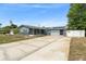 Charming single-story home with a long driveway, attached garage, screened porch, and solar panels for energy efficiency at 1328 Laurel Dr, Daytona Beach, FL 32117