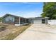 A charming single-story home with blue siding, brick accents, solar panels, a screened lanai, and an attached two-car garage at 1328 Laurel Dr, Daytona Beach, FL 32117