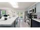 Modern kitchen with stainless steel appliances, a center island, and an open view to the living area at 1328 Laurel Dr, Daytona Beach, FL 32117