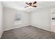 Cozy bedroom featuring gray carpet, neutral paint, a ceiling fan, and a window for ample natural light at 13489 Sw 60Th Avenue Rd, Ocala, FL 34473