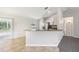 Bright kitchen with white cabinets, stainless steel appliances, and a breakfast bar overlooking the living room at 13489 Sw 60Th Avenue Rd, Ocala, FL 34473