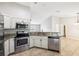 Modern kitchen with stainless steel appliances, granite countertops, and a view into the living area at 13489 Sw 60Th Avenue Rd, Ocala, FL 34473