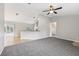 Open living room with gray carpet, neutral paint, a ceiling fan, with easy access to the dining area and kitchen at 13489 Sw 60Th Avenue Rd, Ocala, FL 34473