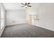 Spacious living room featuring gray carpet, neutral walls, and a ceiling fan, creating a bright and airy atmosphere at 13489 Sw 60Th Avenue Rd, Ocala, FL 34473