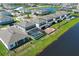 Beautiful aerial view of a home with a screened pool and lush green lawn, surrounded by a lake community at 13617 Haulover Beach Ln, Orlando, FL 32827