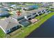 Beautiful aerial view of a home with a screened pool and lush green lawn, surrounded by a lake community at 13617 Haulover Beach Ln, Orlando, FL 32827