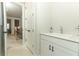 Bright bathroom with white vanity and modern fixtures, adjacent to carpeted hallway and staircase at 13617 Haulover Beach Ln, Orlando, FL 32827
