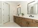 Modern bathroom with dual vanities, stylish mirrors, and a neutral color palette at 13617 Haulover Beach Ln, Orlando, FL 32827