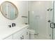 Modern bathroom featuring a glass-enclosed shower and round mirror at 13617 Haulover Beach Ln, Orlando, FL 32827