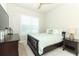 Serene bedroom with a ceiling fan, window and dark wood furniture at 13617 Haulover Beach Ln, Orlando, FL 32827