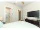 Well-lit bedroom with ceiling fan, connecting door to bathroom and entertainment center at 13617 Haulover Beach Ln, Orlando, FL 32827