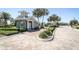 Community gate entrance with a charming guard house and well-maintained landscaping at 13617 Haulover Beach Ln, Orlando, FL 32827