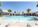 Large community pool surrounded by palm trees and lounge chairs, perfect for relaxation at 13617 Haulover Beach Ln, Orlando, FL 32827