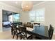 Bright dining room with dark wood table, seating for eight, with a view of the lanai and water at 13617 Haulover Beach Ln, Orlando, FL 32827
