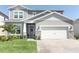 Inviting two-story home with a brick-paved driveway, two-car garage, and a manicured front yard at 13617 Haulover Beach Ln, Orlando, FL 32827