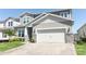 Charming two-story home showcasing a stone-accented facade, well-manicured lawn, and a spacious two-car garage at 13617 Haulover Beach Ln, Orlando, FL 32827