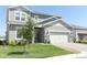 Charming two-story home with a manicured lawn, stone accents, and a two-car garage at 13617 Haulover Beach Ln, Orlando, FL 32827