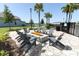 Cozy fire pit area with Adirondack chairs, surrounded by lush landscaping and palm trees at 13617 Haulover Beach Ln, Orlando, FL 32827