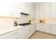 Modern kitchen with white cabinets, stainless appliances, and quartz counters with a chevron backsplash at 13617 Haulover Beach Ln, Orlando, FL 32827