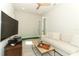 Bright living room with white sofa, modern ceiling fan, and mini-golf setup at 13617 Haulover Beach Ln, Orlando, FL 32827